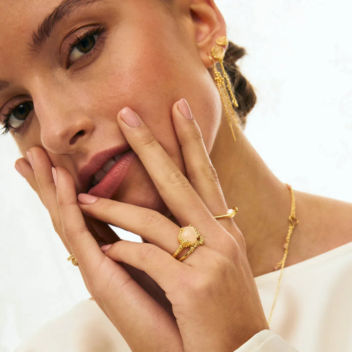Gouden oorbellen, ketting en ringen met parel op model, sieraden close-up