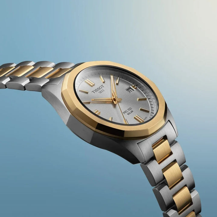 TISSOT PRX Powermatic 80 vises med sølvfarvet urskive, guld detaljer og tofarvet stållænke. Model T151-822-22-031-00.