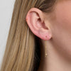 Enamel Copenhagen Daylight Hook ses i øret, et elegant langt guldørering med delikat stjernevedhæng. Model 7207960_1M
