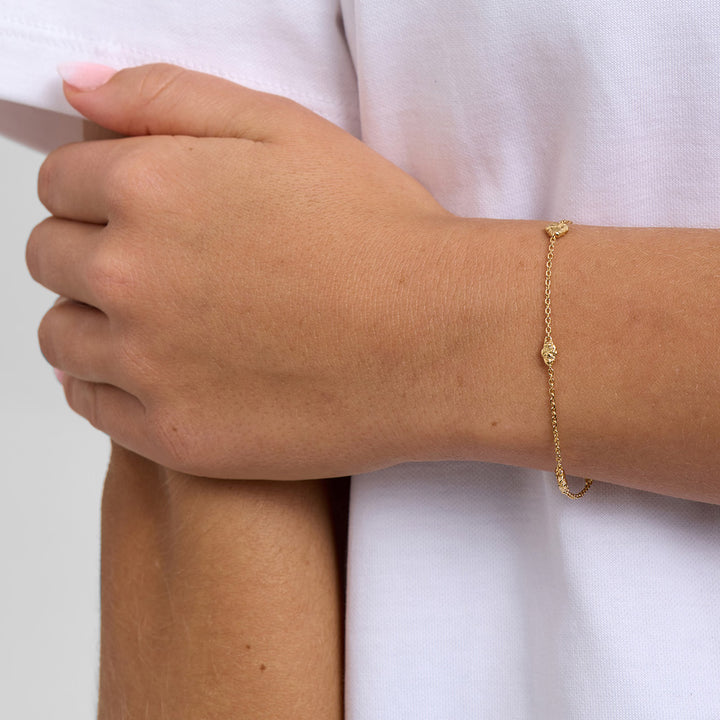 Armbånd 1M vises på håndled, fint guldfarvet kædearmbånd på lys hud. Model 7250954_1M
