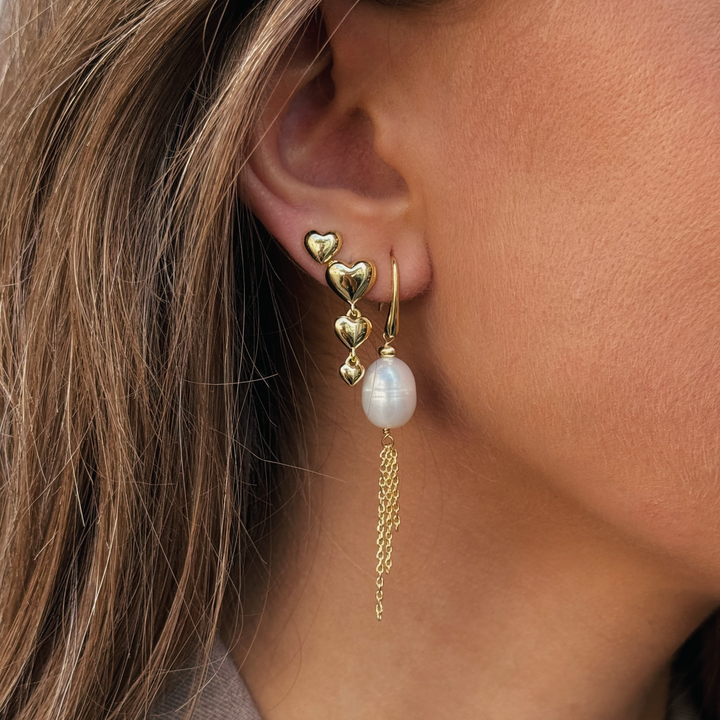 Aqua Dulce Karla And Me Long Earrings toont een elegante gouden oorbel met hartvormige details en parelhanger, model 6422-2.
