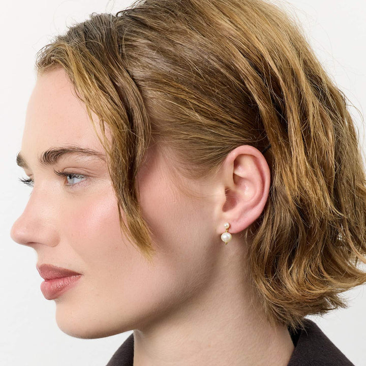 carre-sally-vergulde-oresticks-met-zoetwaterparels afgebeeld op model, crèmekleurige parel en gouden detail. ModelFS4582BI-BI-2