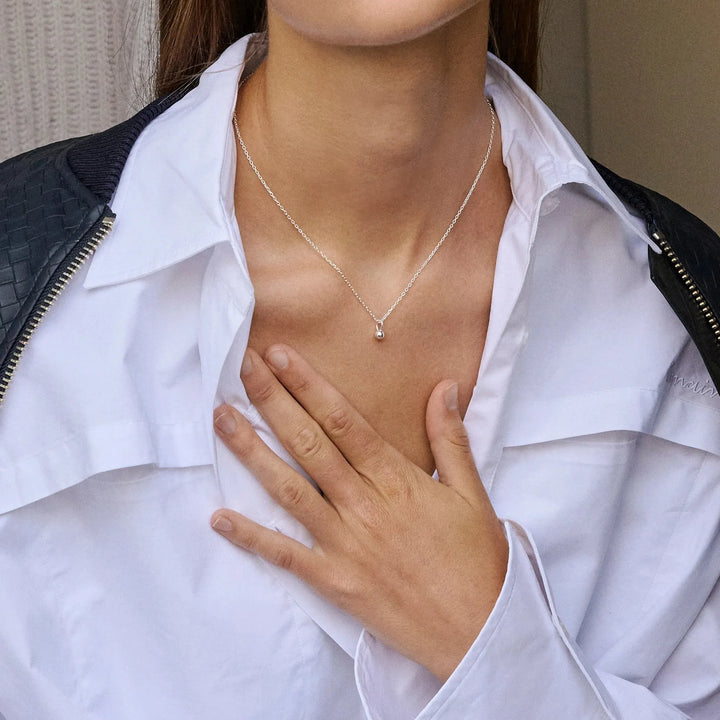 enamel zilveren ballonketting met hanger gedragen door een vrouw die een wit overhemd draagt, model n133s-1