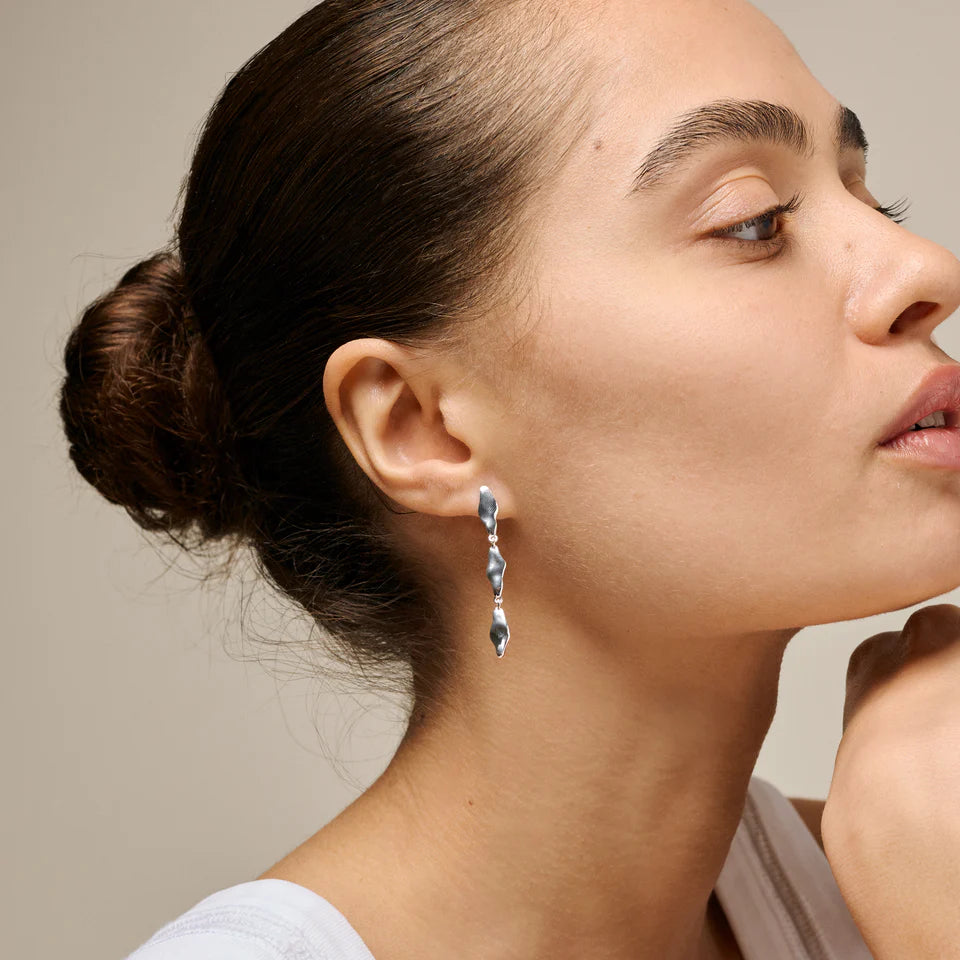 enamel India middelgrote oorbellen in zilver afgebeeld op vrouw, elegant en sculpturaal ontwerp, model e435s-1