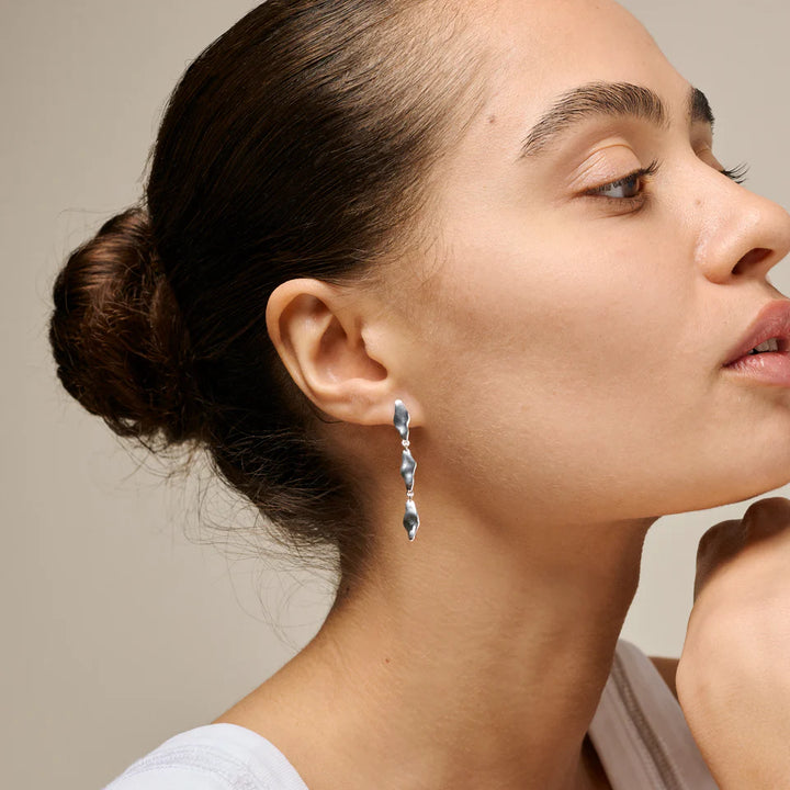 enamel India middelgrote oorbellen in zilver afgebeeld op vrouw, elegant en sculpturaal ontwerp, model e435s-1