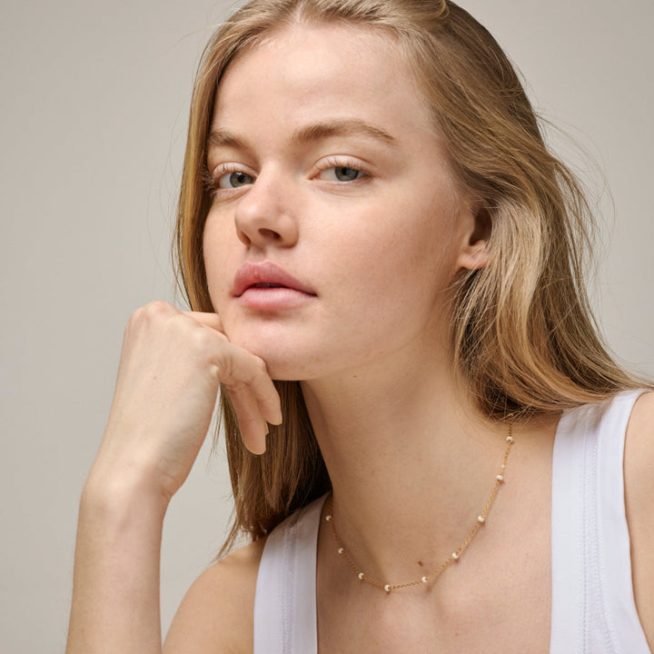 enamel-lola-bolketting-madeliefje-in-verguld-sol n137g madeliefjesafbeelding toont model met eenvoudige, vergulde ketting met fijne details. ModelN137G