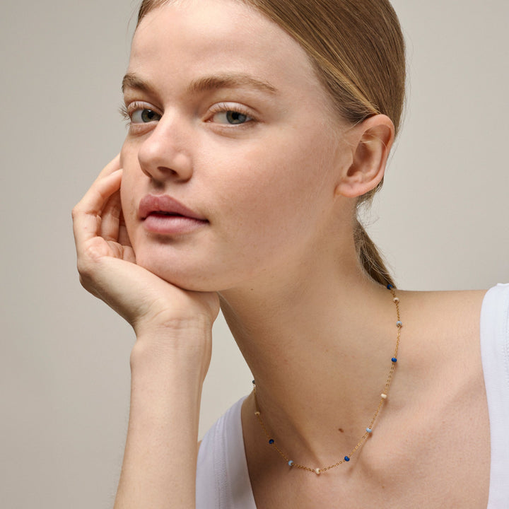 enamel-lola-gedurfde-ketting-marine-in-verguld-sol n137g-marine afgebeeld op model, fijne gouden ketting met blauwe en lichte parels, Model n137g-marine