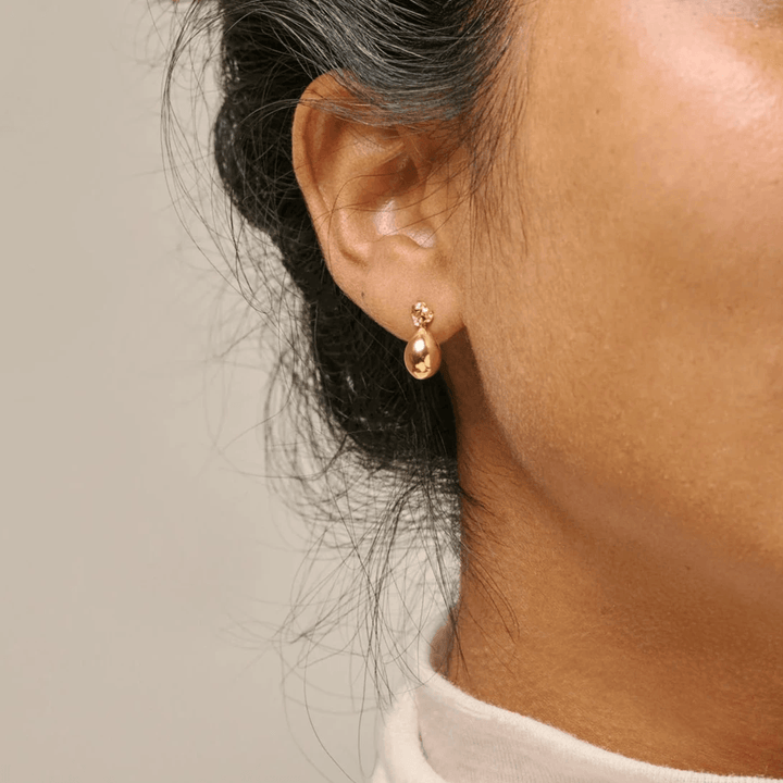 Enamel Poe Studs vergulde oorbellen worden in het oor gedragen en laten een elegant druppelvormig gouden detail zien. Model e385gm