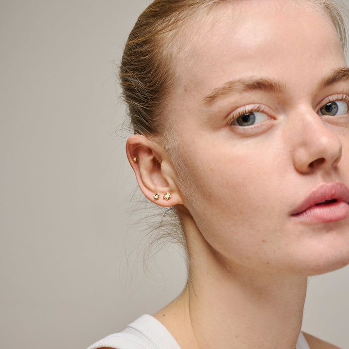 enamel kleine zonneschijnoorbellen madeliefje e420g madeliefje afgebeeld gedragen op oor door model, goudkleurig ontwerp, model e420g madeliefje-2