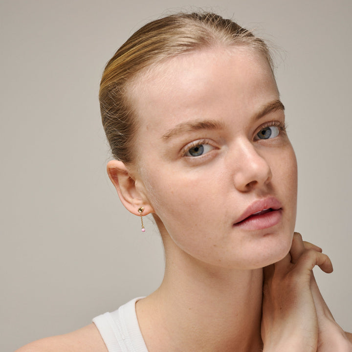 Enamel Sunshine Drop Earrings Pink is te zien op model met opgestoken haar. Goudkleurige oorbellen met roze detail. Model e423g-roze-2.