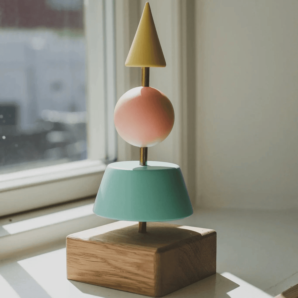 Fablewood Kerstboom Helga-1213 met geometrische boomvormen in gele, groene en roze tinten op een eikenhouten voet. Model 1213-1