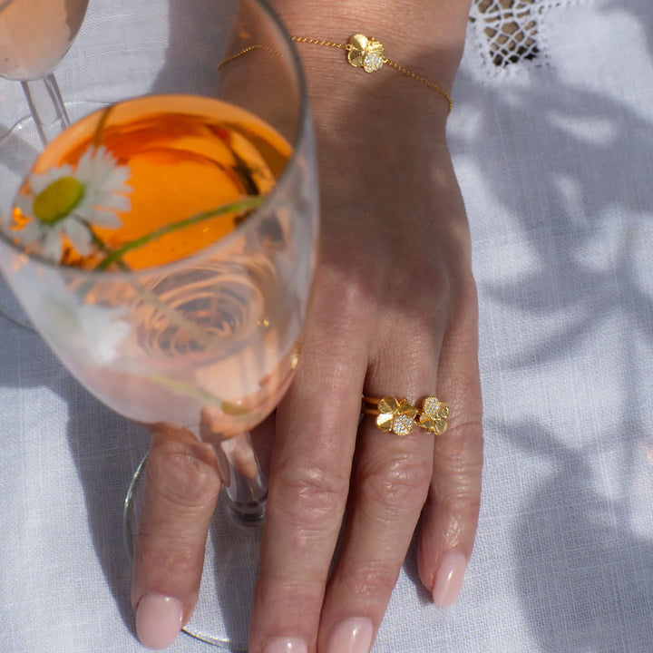 Flora Danica Klavertje Vier Ring Pavé Gilded toont een elegante goudkleurige ring met klavertje vier op de hand. Model 907-flc-ri-g-pave-001-2