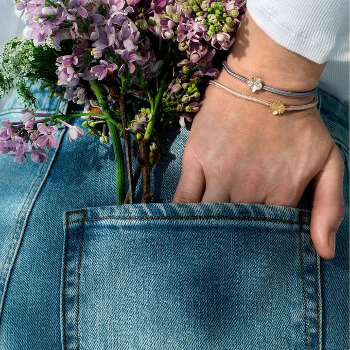Flora Danica Firklover Zijden Armband Blauw Zilver verschijnt om de pols, met bloemen en denim, Model 907-flc-silk-blue-s-001
