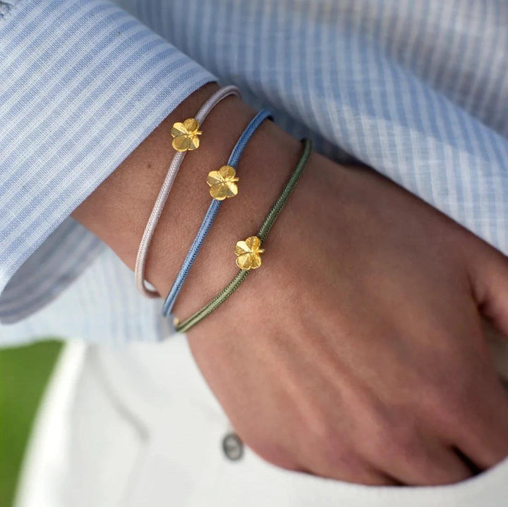 Flora Danica Klavertjevier Zijden Armband Olijf Verguld toont gouden klavertjesvier op een olijfgroen zijden lint, Model 907-flc-silk-olijf-g-001-2.