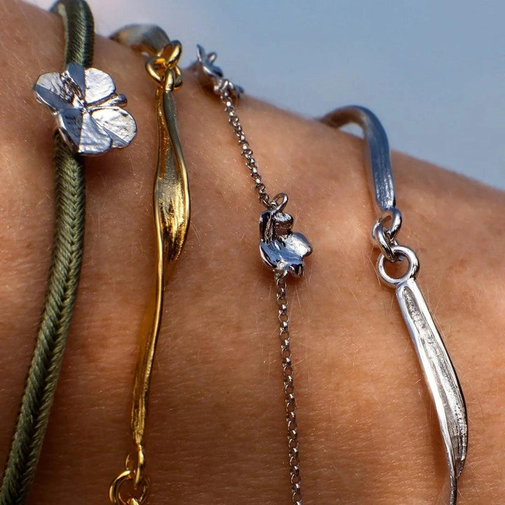 Flora Danica Klaver Zijden Armband Olijf Zilver is te zien aan de pols, olijfgroen zijden koord en klaverdetail. Model907-FLC-SILK-OLIVE-S-001-2