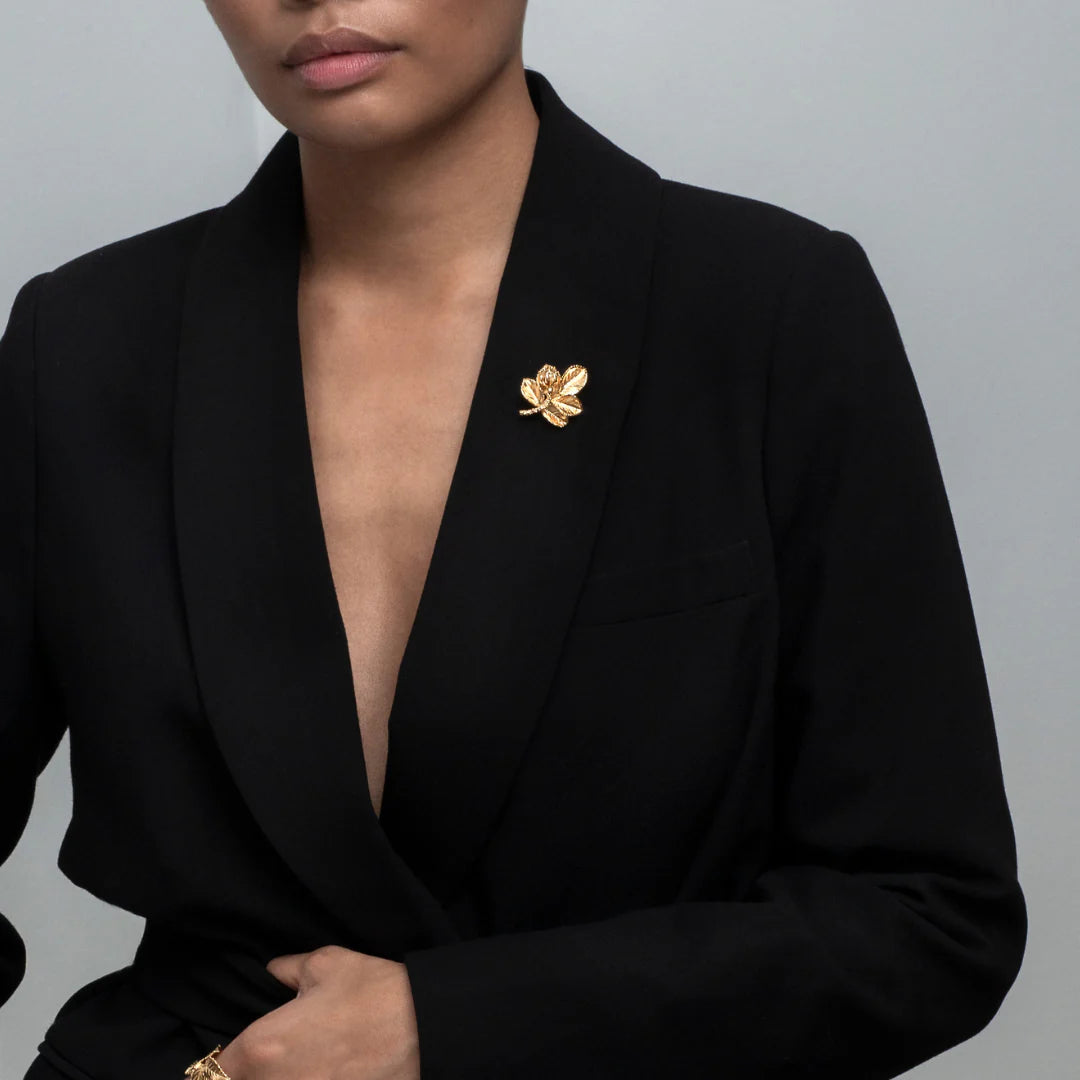 Flora Danica Rosenblad broche Vergulde rozenbroche afgebeeld op een zwarte blazer, elegant en gedetailleerd. Model bro-g-1