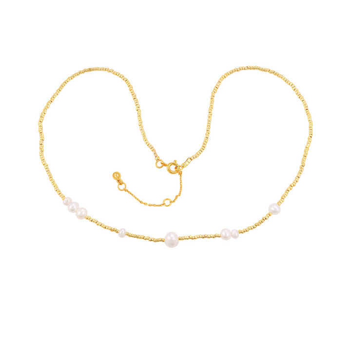 Hultquist Copenhagen Aria Parelsnoer, elegante goudkleurige ketting met kleine witte parels, model S08623G-1.
