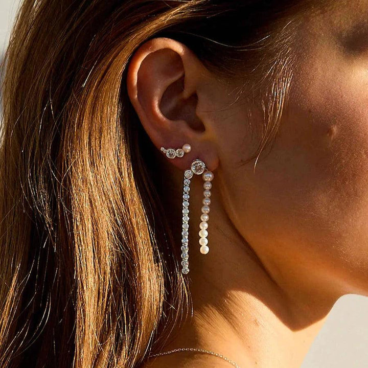 Hultquist Copenhagen Zilveren Harper Croissant-oorbel afgebeeld op het oor met glanzende afwerking in zonlicht. ModelS08607S-2