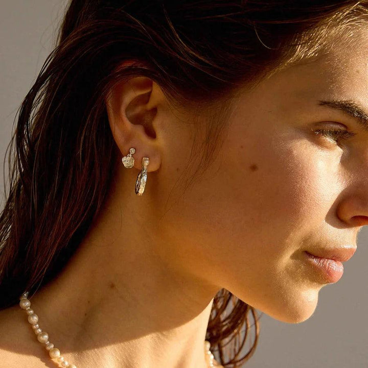 Hultquist Copenhagen Lainey Petite zilveren oorknopjes afgebeeld op model met parelketting in zonlicht. ModelS08610S-2