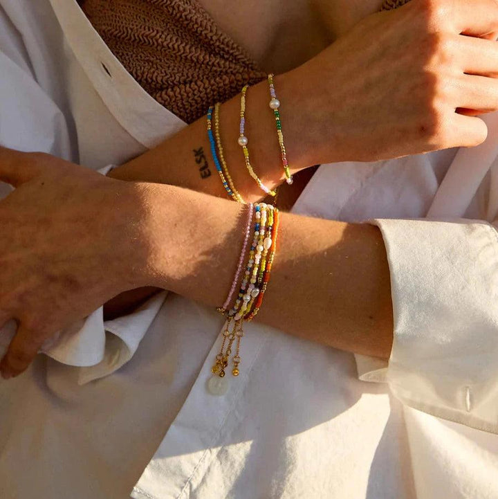 Hultquist Copenhagen Paisley Parelarmband met gekleurde parels en pareldetails op de arm van de vrouw in zonlicht. ModelS08619G-2