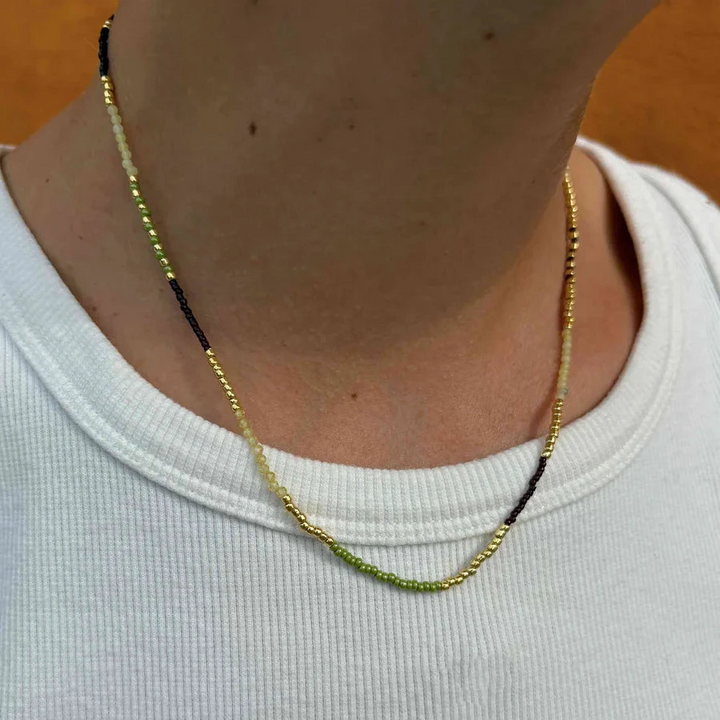 Hultquist Lucky Necklace wordt dicht bij de nek getoond, parels in groen, zwart en goud. ModelS08637G-2