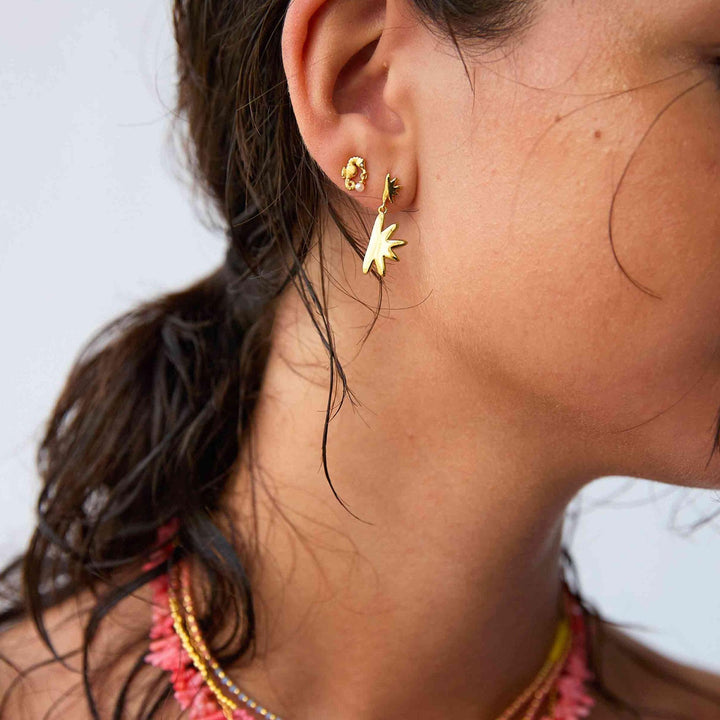 Hultquist Sandy oorbellen verguld verschijnen op het oor van de vrouw met stervormig detail. ModelS08497G-2