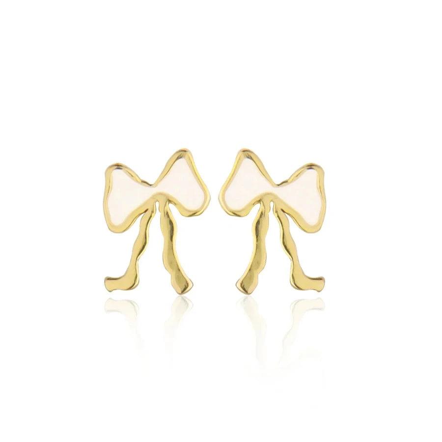 Jeberg Petite Bow White Stud Bow Earrings toont een paar kleine goud- en witkleurige strikoorbellen. Model 52815-1
