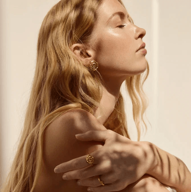 Jeberg Pirouette Darling oorbellen worden getoond op een vrouw, gouden kleur, elegante stijl. Model 52870-2