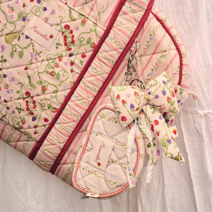 De Moonstone Fabric Bow Key Ring Garden Magic Ivory verschijnt op een gewatteerde tas, bloemen en pastel. Model 4111 - één maat