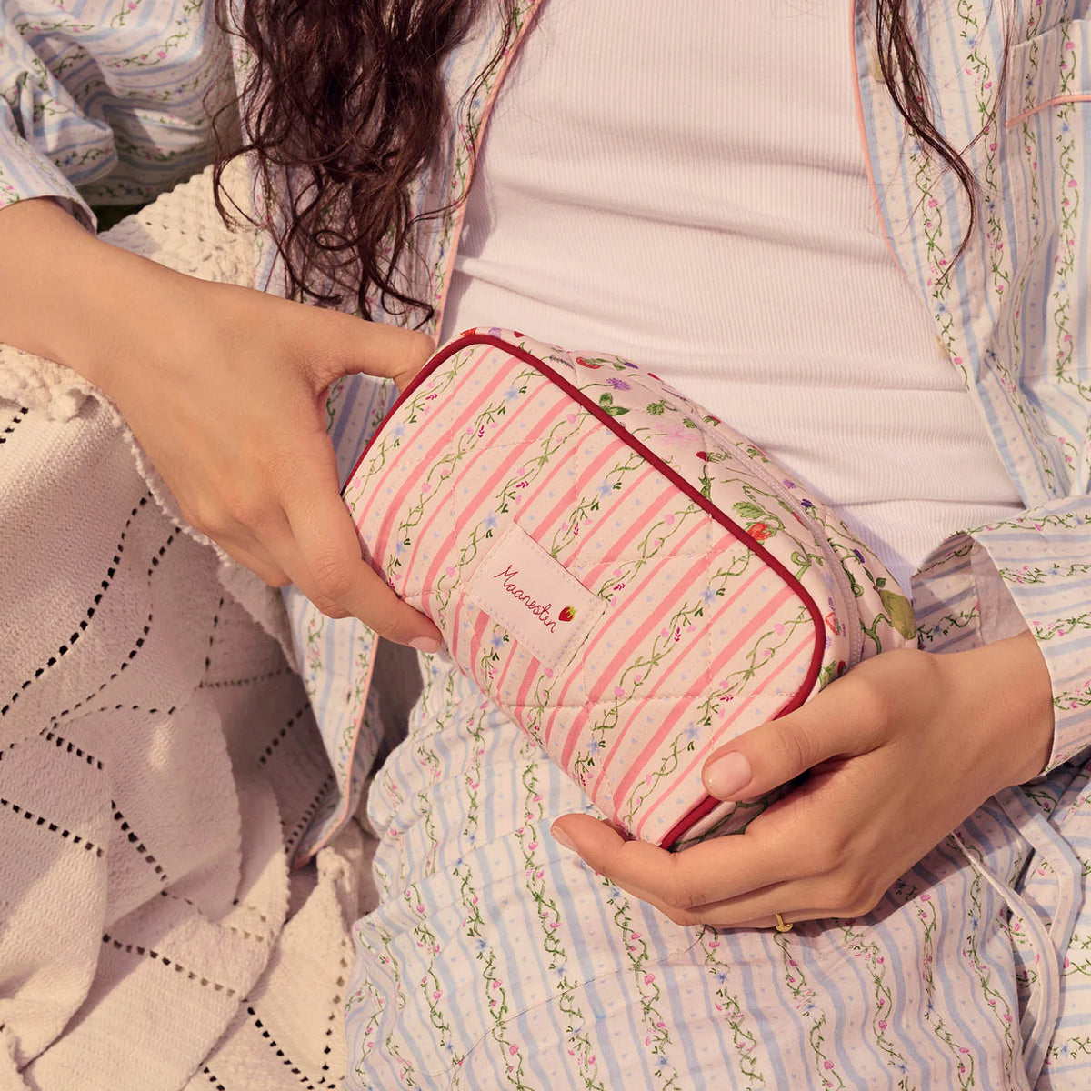 maansteen-stardust-bag-zomerstrepen-perzik met roze en groen gestreepte bloempatronen wordt op schoot gehouden. Model4114-één maat