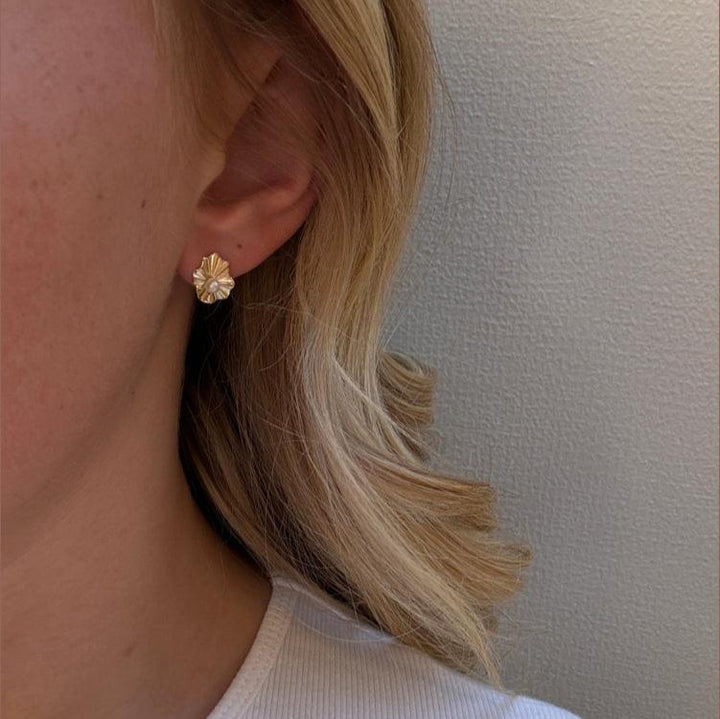 Mads Z Amelie 8kt gouden oorstekers met parel verschijnen op het oor, elegant en stijlvol detail. Modelnummer 3313119.