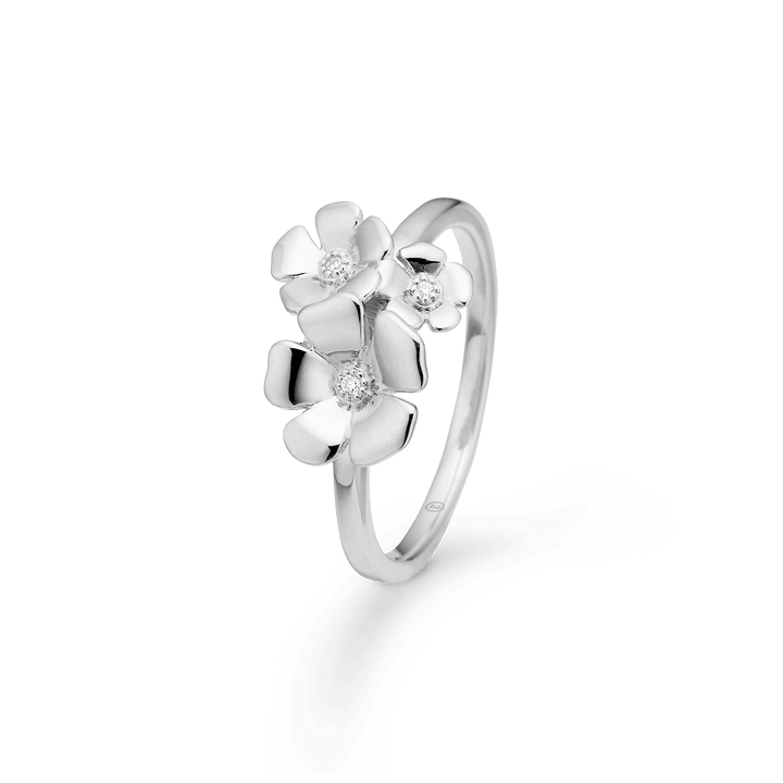 Mads Z Fleur Zilveren Ring met Witte Topaas toont een elegante zilveren ring met drie bloemen en heldere stenen. Modelnummer 2146108-001
