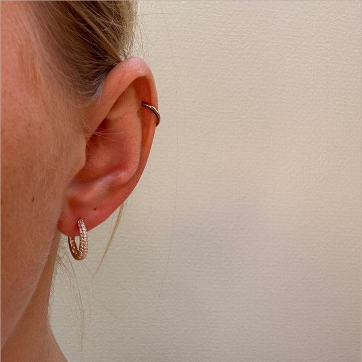 Mads Z La Boheme 8kt gouden creool met zirkonia verschijnt op het oor, elegant en sprankelend. Model3317030-2