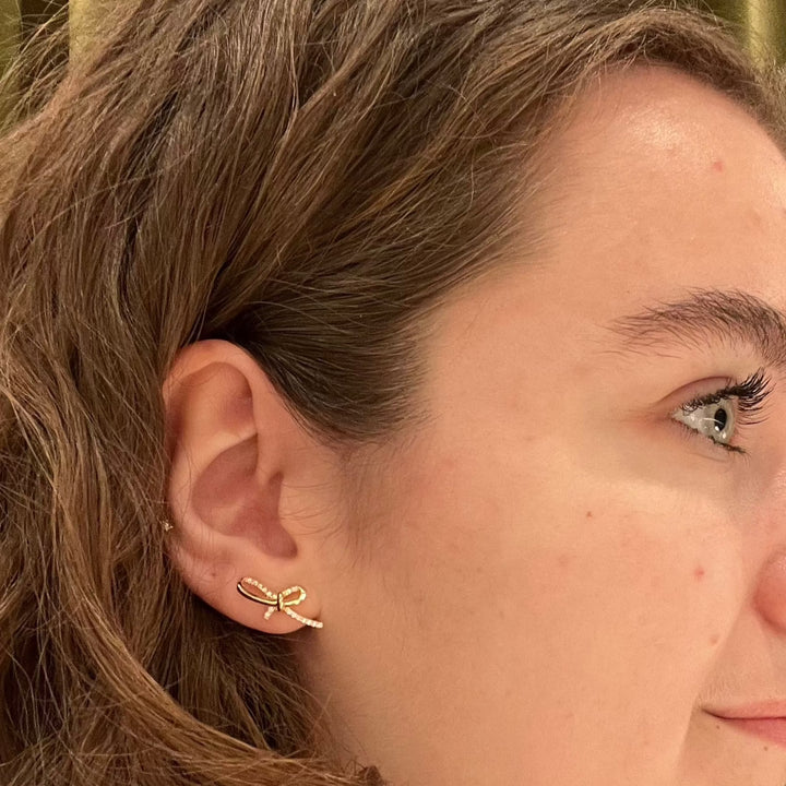 Mads Z Miss Butterfly oorbellen met strik in goud met diamanten zichtbaar op het oor van de vrouw, model 1511003-2