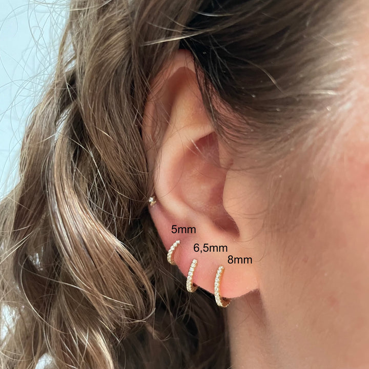 Maria Tash 6,5 mm Diamond Eternity Ring 18kt verschijnt in het oor, elegante gouden ring met fonkelende diamanten. ModelXET65D-2