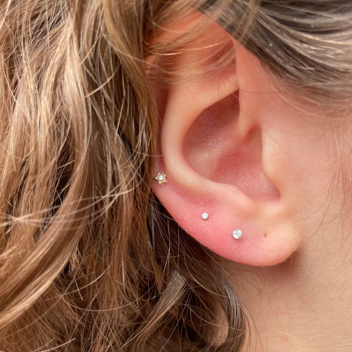 Maria Tash Diamond Solitaire Star ørestik i guld, forside på øre. Model 48295.