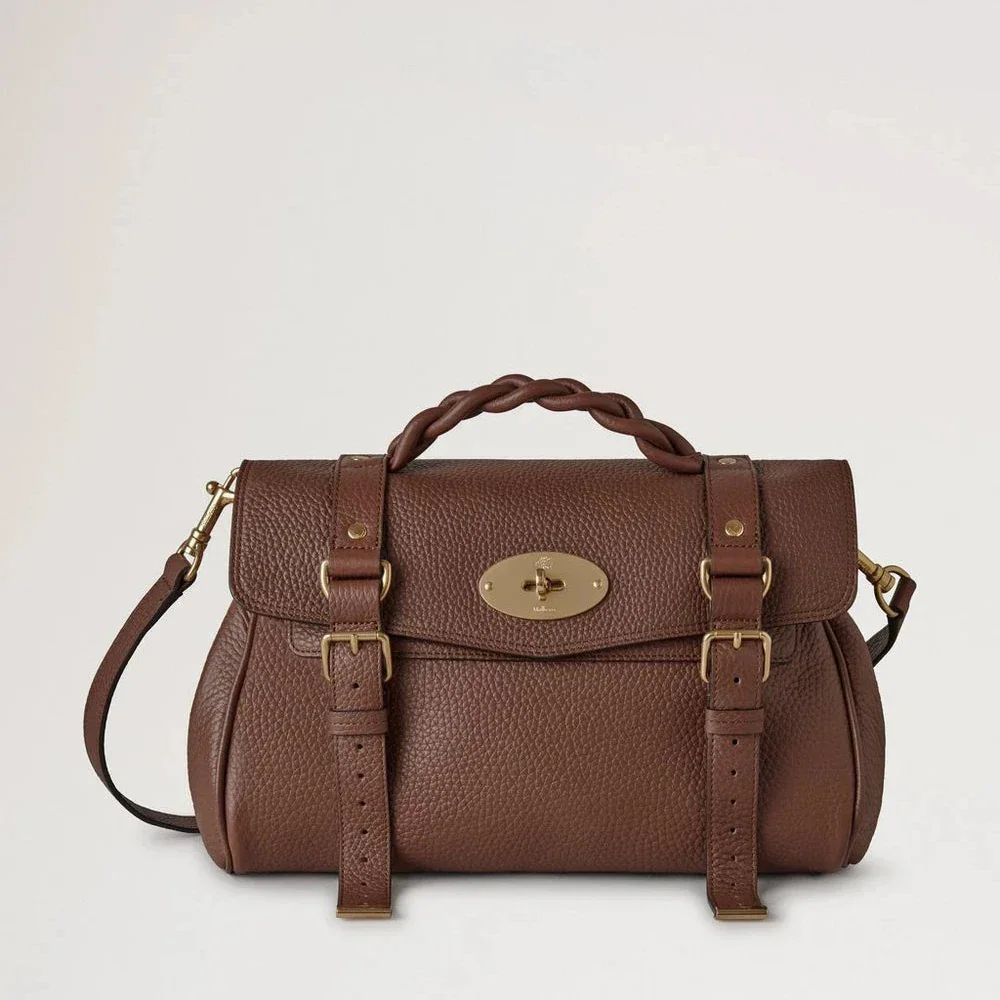 Mulberry Alexa Heavy Grain Bright Oak toont een bruinleren tas met gevlochten handvat en gouden details. ModelHH6746/736G222.