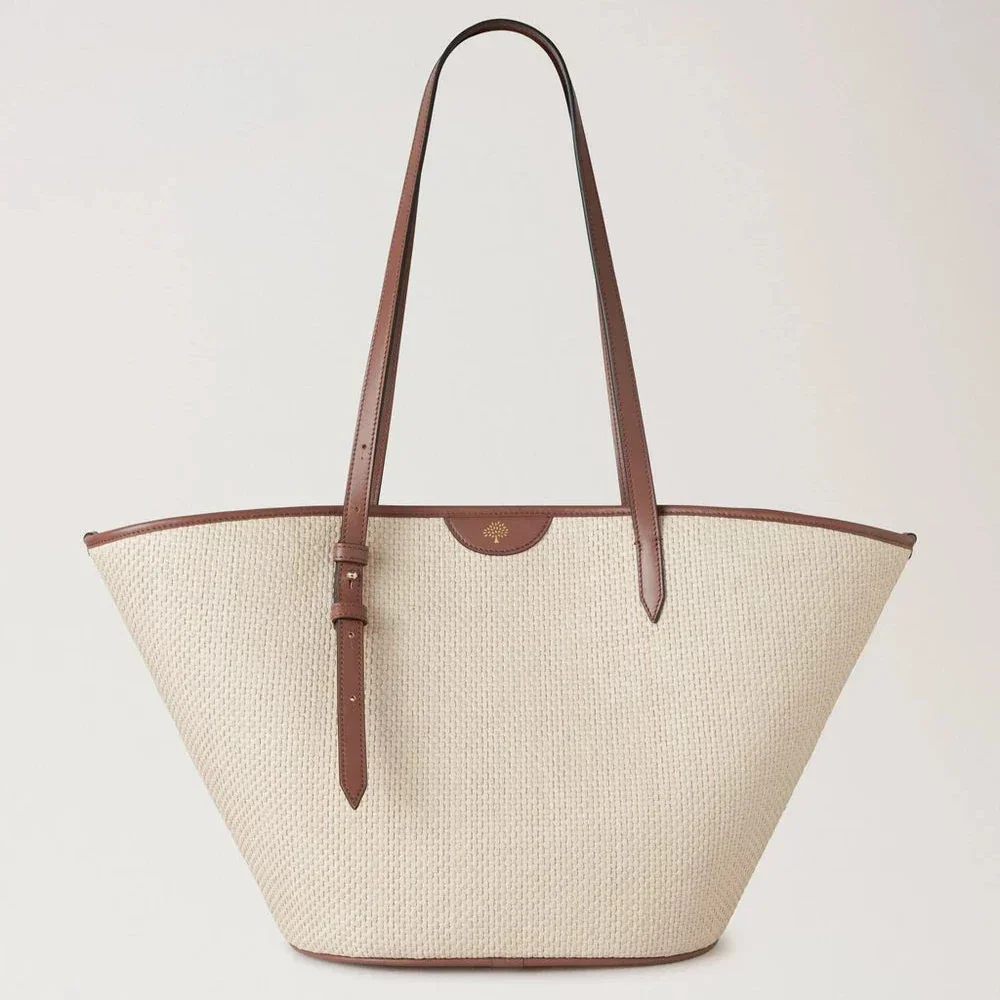 Mulberry Basket Tote Palma Leaf Oak toont een grote rieten tas met bruin leren handvat en crèmekleurige body. ModelHH9796000G110.