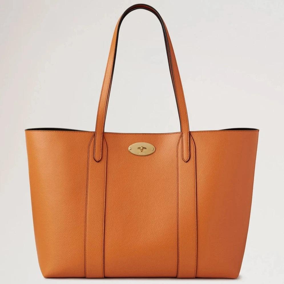 Mulberry Bayswater Tote Small Classic Grain Sunset toont een ruime oranje leren tas met gouden details. Modelhh7436205n691