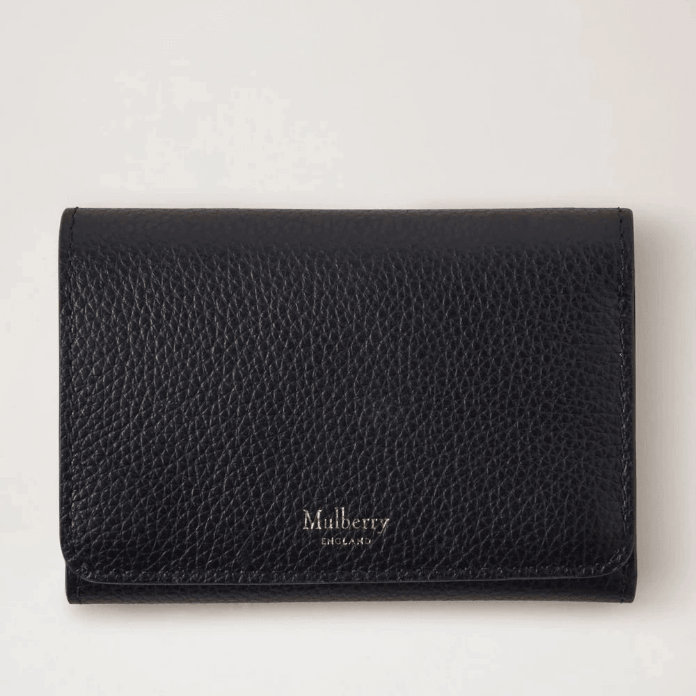 Mulberry Continental Trifold-kaarthouder zwart in zwart leer met reliëf, vanaf de voorkant gezien in een studio-omgeving. Modelrl6824205a100