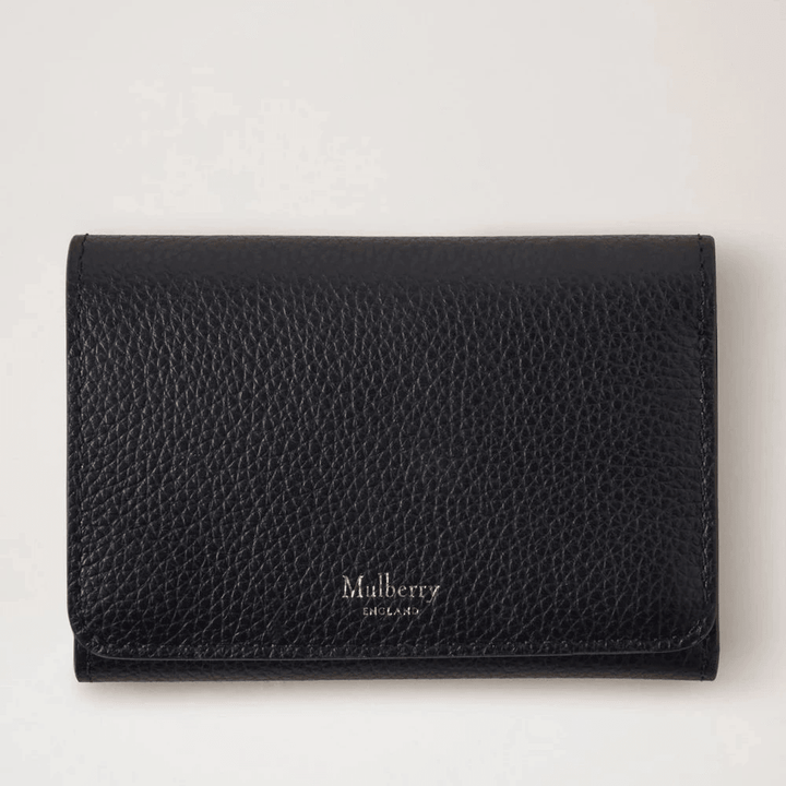 Mulberry Continental Trifold-kaarthouder zwart in zwart leer met reliëf, vanaf de voorkant gezien in een studio-omgeving. Modelrl6824205a100