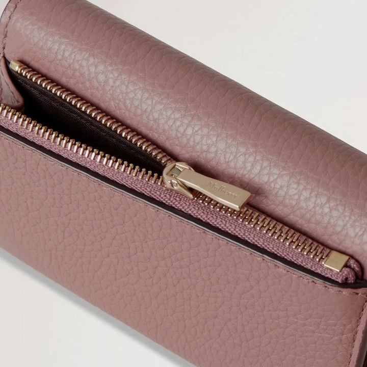 Mulberry Continental Trifold Wallet toont textuur en gouden rits in stoffig roze leer, gedetailleerde uitsparing.