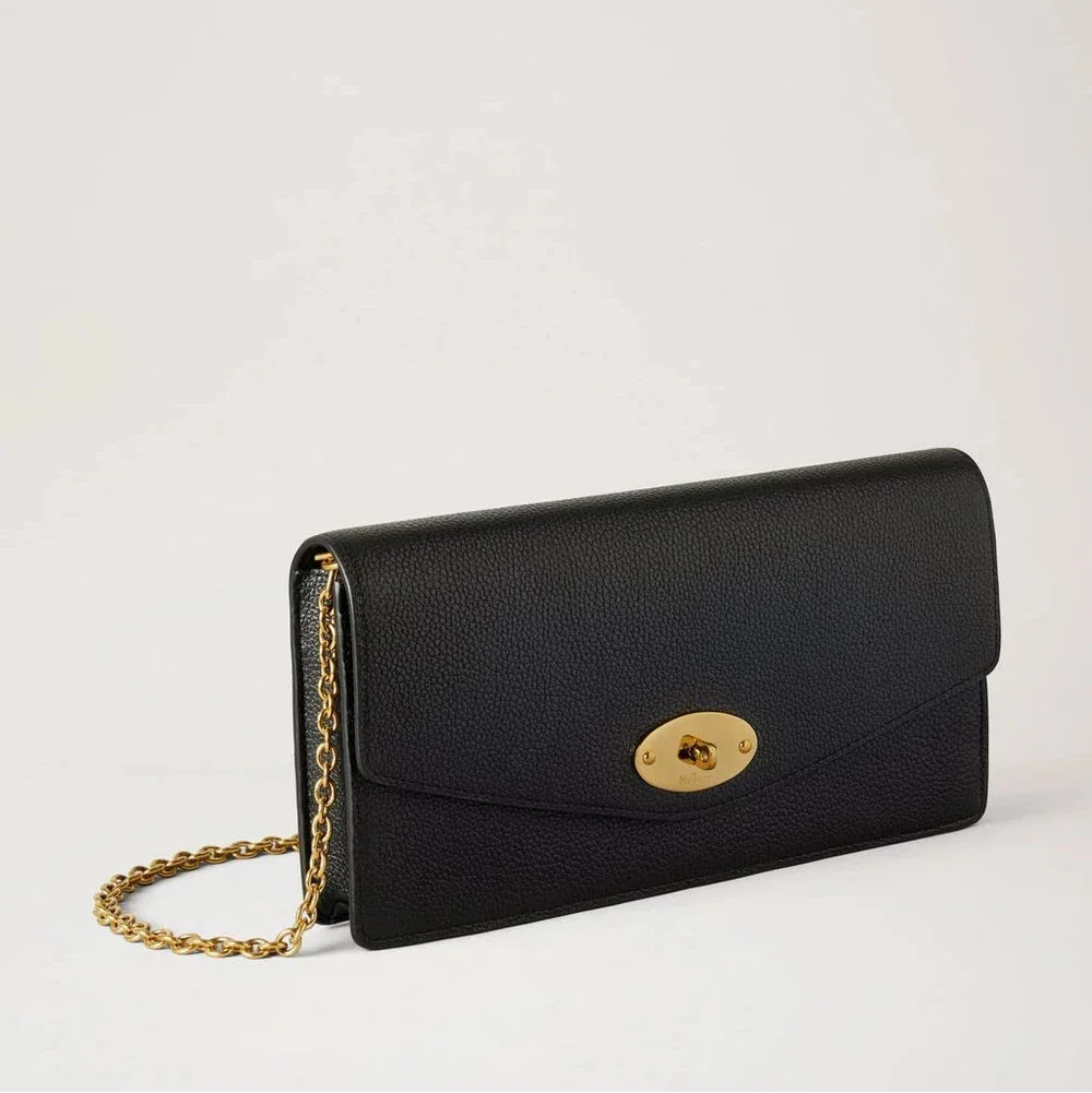 Mulberry Darley Clutch Small Classic Grain Black toont een elegante zwarte clutch van leer met gouden ketting en draaislot aan de voorkant. ModelRL8971205A100