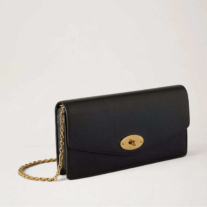 Mulberry Darley Clutch Small Classic Grain Black toont een elegante zwarte clutch van leer met gouden ketting en draaislot aan de voorkant. ModelRL8971205A100