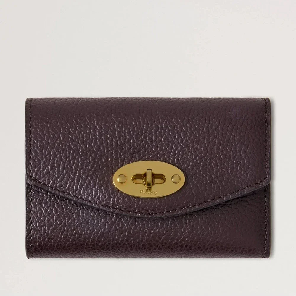 Mulberry Darley Folded Multicard Wallet Small Classic Grain Ebony toont een kleine bruine portemonnee van reliëfleer met een gouden draaisluiting. ModelRL6665205A110