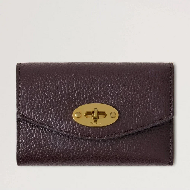 Mulberry Darley Folded Multicard Wallet Small Classic Grain Ebony toont een kleine bruine portemonnee van reliëfleer met een gouden draaisluiting. ModelRL6665205A110