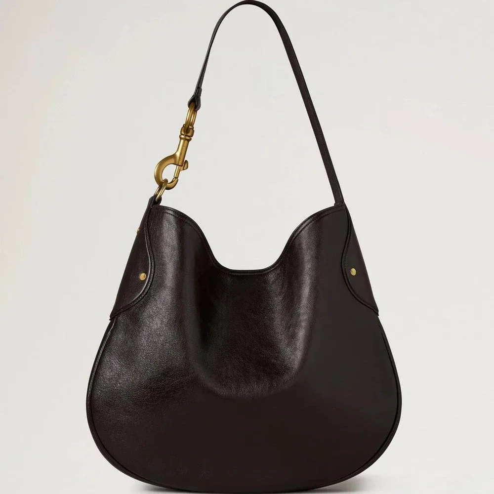 Mulberry Hackney Schoudertas Ebony Shiny Buffalo toont een elegante donkere schoudertas van glanzend leer met gouden details. Modelhh9963726a110