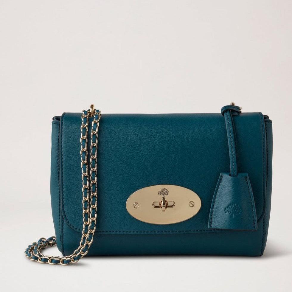 Mulberry Lily Micro Classic Grain Titanium Blue toont een klein blauw leren schoudertasje met gouden ketting. ModelHH9179587T622