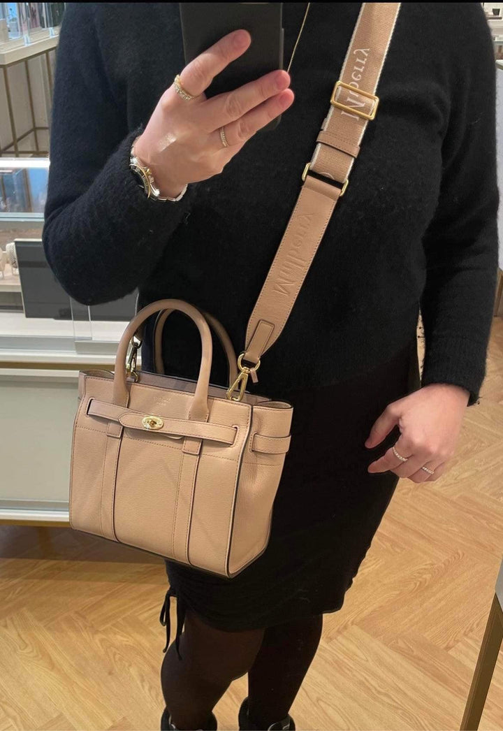 Mulberry-logo-webbing-riem-esdoorn-rx0283000e631 gedragen op de schouder, beige tas met brede logoriem, model rx0283000e631.