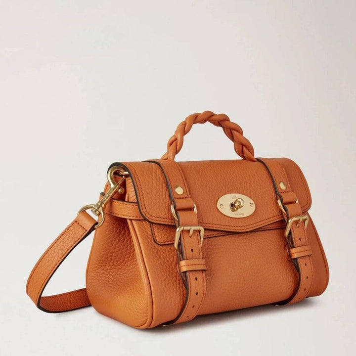 Mulberry De Mini Alexa Heavy Grain Sunset wordt weergegeven in zwaar oranje leer met gevlochten handvat en gouden details. ModelRL6595736N691.